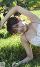 A woman laying in the grass next to a bunch of grapes.