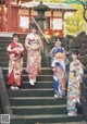 A group of women in kimonos standing on some steps.