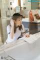 A woman in a white shirt is sitting in a bathtub.