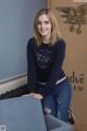 A woman sitting on top of a couch next to a wall.